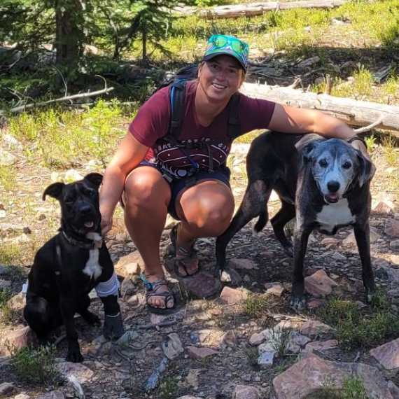 Jordan with her two dogs on a hike in the mountains